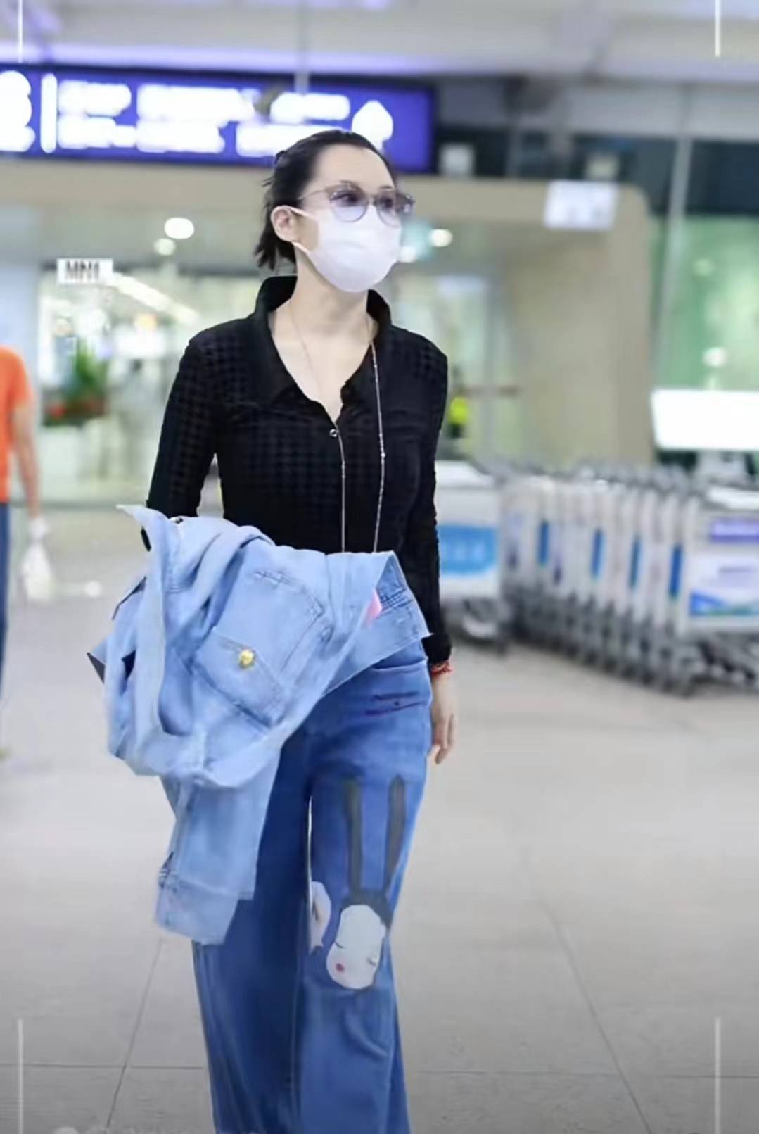 许晴穿"牛仔衣 阔腿裤"出机场,面带笑容频看手机,时髦洋气心情好