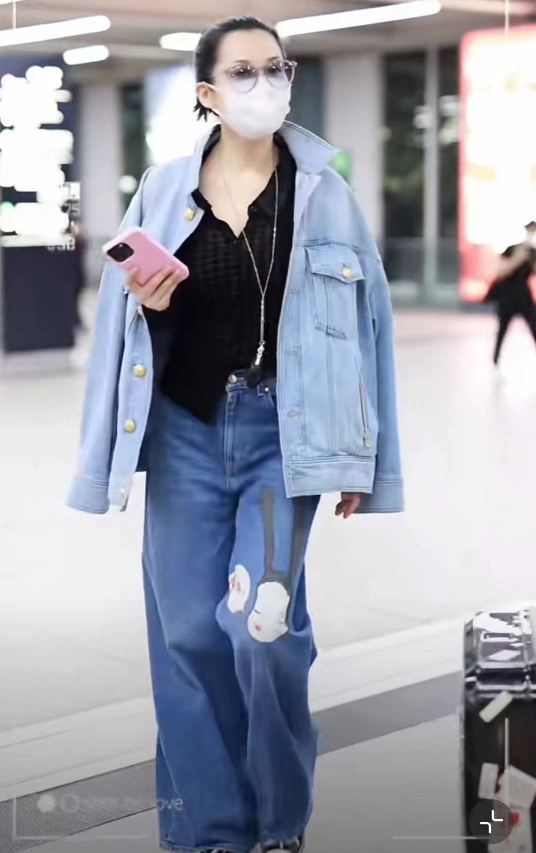 许晴穿"牛仔衣 阔腿裤"出机场,面带笑容频看手机,时髦洋气心情好