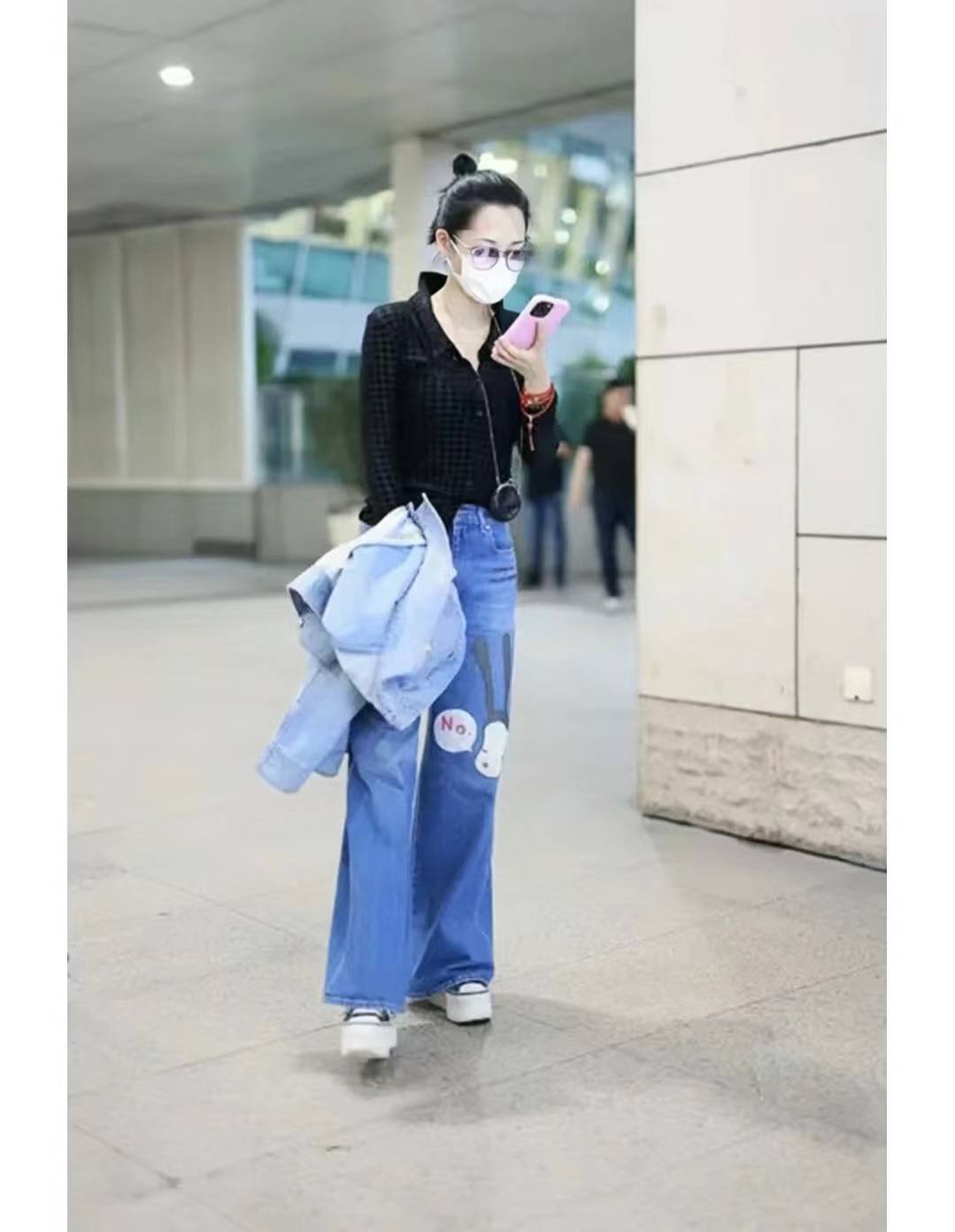 许晴穿"牛仔衣 阔腿裤"出机场,面带笑容频看手机,时髦洋气心情好