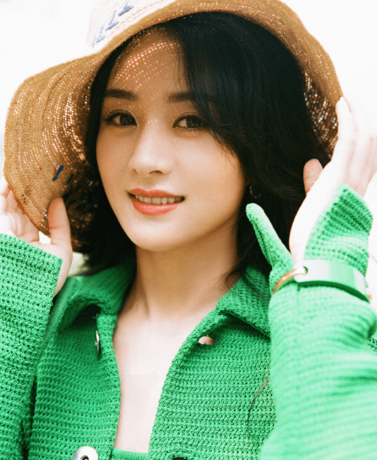 双手扶着帽子的边缘,阳光穿透草帽的空隙照射在赵丽颖的额头上,肤白貌